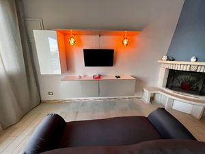 Entspannendes Wohnzimmer mit Kamin, Sofa und Smart-TV