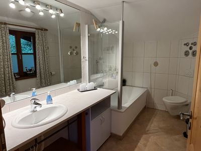 Badezimmer mit Duschwanne und großem Spiegel