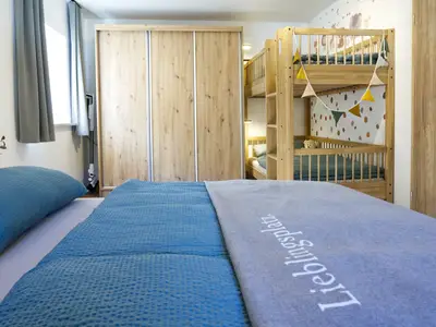 Schlafzimmer mit großem Doppelbett, Etagenbett und geräumigen Kleiderschrank