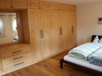 Das Schlafzimmer mit großzügigem Einbauschrank in Fichte massiv und großem integrierten Spiegel