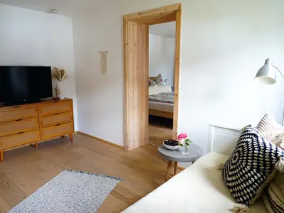Wohn-/Esszimmer mit TV, Blick ins Schlafzimmer