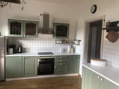 Küche mit E-Herd, Kühlgefrierschrank, Wasserkocher, Toaster, Kaffeemaschine und Esstisch für 3 Personen