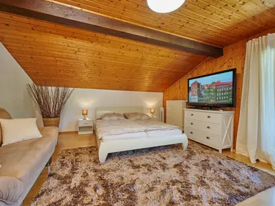 Haupt-Schlafzimmer (voll abdunkelbar) mit Doppelbett, Couch, Flat-TV und großen Balkontüren; Ventilator