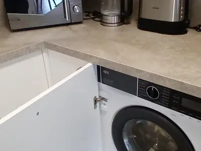 Küche mit Wasserkocher, Waschmaschine und Trockner