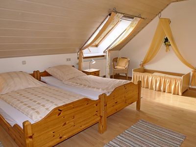 Schlafzimmer mit 2 Einzelbetten als Doppelbett und Kleinkinderbett