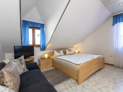 Gemütliches Schlafzimmer mit großem Fernseher