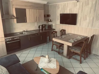 Wohnküche mit TV und großem Tisch