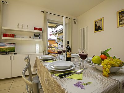 Das Wohnzimmer mit Esstisch, TV und Ausgang zum Balkon