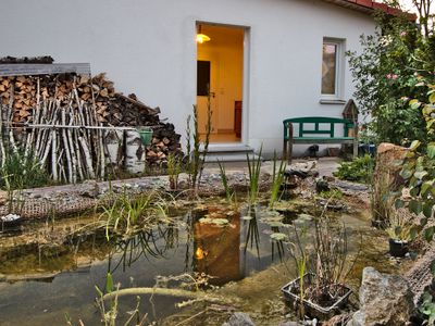Außenbereich mit Teich und Blick in Küche und zum Badfenster