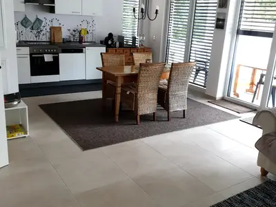 Große, geräumige Wohnküche mit Schlafsofa und mit Blick auf großzügigen Balkon