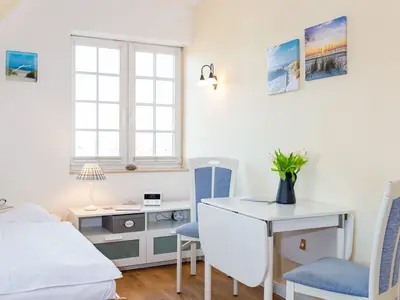 Der Bereich zwischen Bett und Esstisch in der Ferienwohnung Wattstübchen in Norddorf auf Amrum
