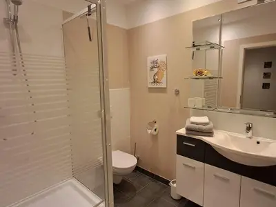 das Bad mit Dusche und Handtuchtrockner