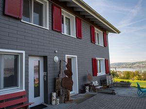 Gästehaus mit Eingang, Sitzplatz und Sicht auf Sempachersee