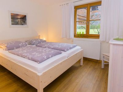 Schlafzimmer mit Doppelbett und Einbauschrank. Blick auf den Berg Risskopf