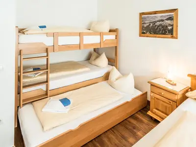 Schlafzimmer mit Doppelbett, Stockbett und Einzelbett