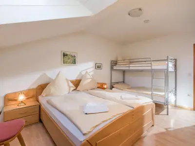 Das Schlafzimmer mit Doppelbett und Stockbett in der Ferienwohnung Nr. F8