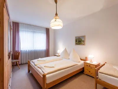 Das Schlafzimmer mit Doppel- und Einzelbett in der Ferienwohnung Nr. F5