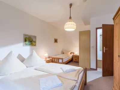 Das Schlafzimmer mit Doppel- und Einzelbett in der Ferienwohnung Nr. F5