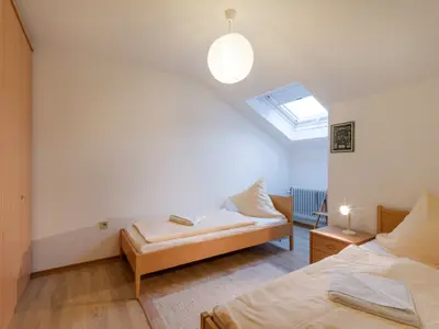 Schlafzimmer mit Doppel- und Einzelbett in der Ferienwohnung Nr. E7