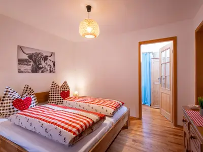 Schlafzimmer mit Doppelbett und Zugang zum WC