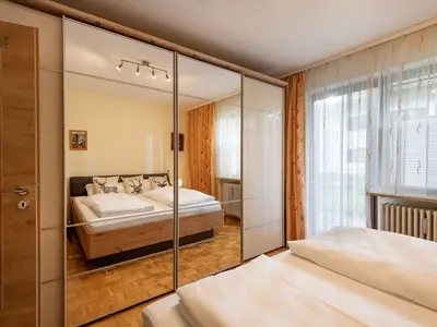 Schlafzimmer mit Doppelbett und Zugang zum Garten