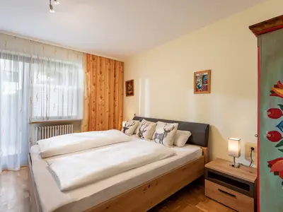 Schlafzimmer mit Doppelbett und Zugang zum Garten