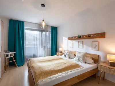 Schlafzimmer mit Doppelbett und Zugang zum Balkon