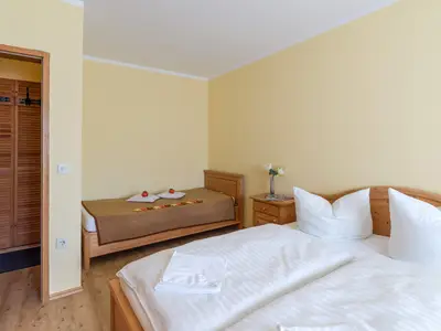 Schlafzimmer mit Doppel- und Einzelbett in der Ferienwohnung Nr. E5