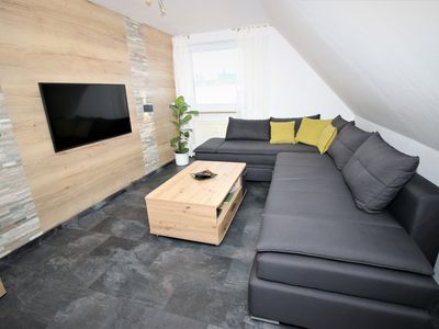 Wohnzimmer mit Schlafcouch und Smart-TV