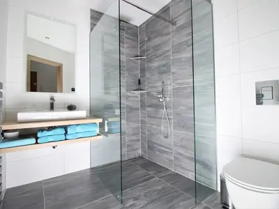 Bad mit ebenerdiger Regendusche und Fußbodenheizung