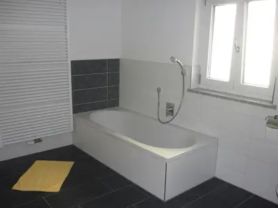 Badezimmer mit ebenerdiger Dusche und Badewanne