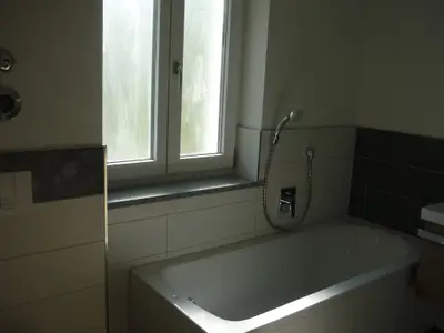Badezimmer mit ebenerdiger Dusche und Badewanne