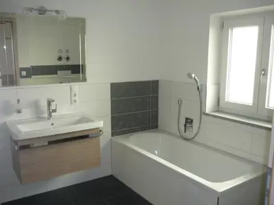 Badezimmer mit ebenerdiger Dusche und Badewanne