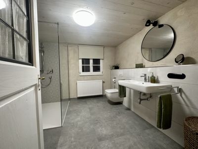 Geräumiges Badezimmer mit begehbarer Dusche, großem Waschbecken und WC