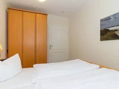 Schlafzimmer mit Doppelbett und Kleiderschrank