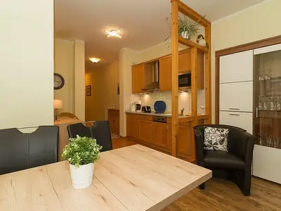 Wohn-Essbereich mit Esstisch, Sitzgelegenheit und Küchenzeile