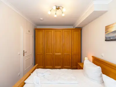 Schlafzimmer mit Doppelbett und Kleiderschrank