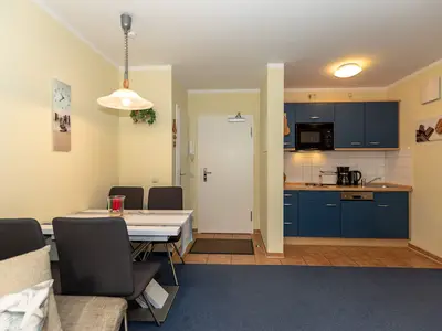 Wohn-Essbereich mit Esstisch, Sitzgelegenheit und Küchenzeile