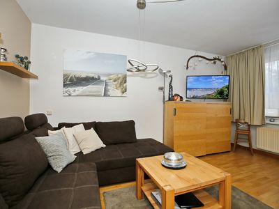 Wohnzimmer mit Schlafcouch, Sideboard und TV