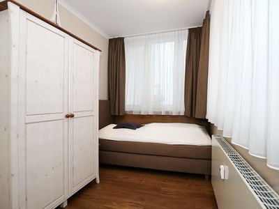 zweites Schlafzimmer mit Boxspringbett und Kleiderschrank