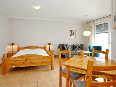 Wohnzimmer mit Doppelbett und Essbereich