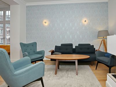 Wohnzimmer mit Schlafcouch und Sesseln