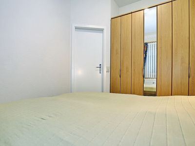 Schlafzimmer mit Doppelbett und Kleiderschrank