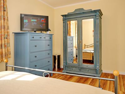 Schlafzimmer mit Kleiderschrank, Kommode und TV