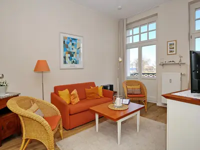 Wohnzimmer mit Schlafcouch und Korbsesseln Wohnzimmer mit Schlafcouch und Korbsesseln
