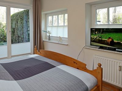 Schlafzimmer mit Doppelbett und TV