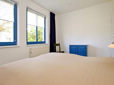 erstes Schlafzimmer mit Doppelbett und Kommode