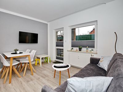 Wohnzimmer mit Schlafcouch und TV