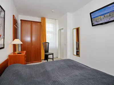Schlafzimmer mit Doppelbett und TV