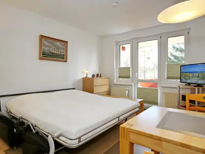 Wohnzimmer mit ausgeklappter Schlafcouch und TV Wohnzimmer mit ausgeklappter Schlafcouch und TV
